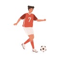 Young female football player running up to kick ball forward. Woman playing European soccer in red sports outfit, boots Royalty Free Stock Photo