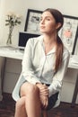 Young woman freelancer indoors home office concept formal style sitting dreaming