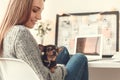 Young woman freelancer indoors home office concept winter atmosphere sitting with puppy Royalty Free Stock Photo