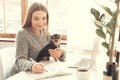 Young woman freelancer indoors home office concept winter atmosphere with dog Royalty Free Stock Photo