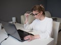 Home office, business girl with glasses working on a laptop. Royalty Free Stock Photo