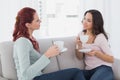 Young female friends chatting over coffee at home Royalty Free Stock Photo