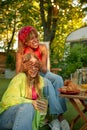 Young female friends at outdoor picnic celebrating summertime vacation