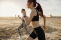 Young athletic women in sportswear is jogging along shore of beach. Concept of healthy living Royalty Free Stock Photo