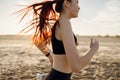 Close up of athletic women in sportswear is jogging along shore of beach. Concept of healthy living Royalty Free Stock Photo