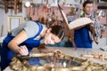 Young female furniture maker diligently working on vintage mirror in workshop