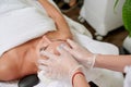 Young female getting facial treatment in spa cosmetologist wearing gloves professional services