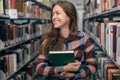 Young female girl student smiling with book in library Royalty Free Stock Photo