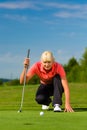 Young female golf player on course aiming for put Royalty Free Stock Photo