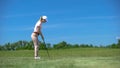 Young female golfer practicing shots with iron club at course, sport and hobby Royalty Free Stock Photo