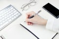 A young female hand writes with a pen in a checkered notebook with a pen Royalty Free Stock Photo