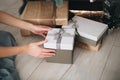 Young female hands holding gift box near the Christmas tree. New Year atmosphere Royalty Free Stock Photo