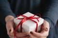 Young female hands holding gift box with red ribbon Royalty Free Stock Photo