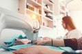 Young female hands and sewing machine of close-up. Two young woman designer of clothes working in creative studio Royalty Free Stock Photo
