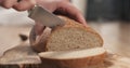 Young female hands slicing rye wheat rustic bread on cutting board Royalty Free Stock Photo