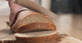 Young female hands slicing rye wheat rustic bread on cutting board Royalty Free Stock Photo