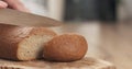 Young female hands slicing rye wheat rustic bread on cutting board Royalty Free Stock Photo