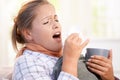 Young female having flu laying in bed sneezing Royalty Free Stock Photo