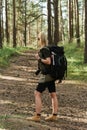 Female hiker with big backpack in green forest