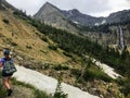 A young female hiker navigating the forests, rocky mountain terrain, and snow covered valleys of the Rocky Mountains