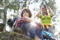 Young female hiker photographing through digital camera while man looking away in forest Royalty Free Stock Photo