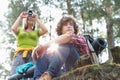 Young female hiker photographing through digital camera while man looking away in forest Royalty Free Stock Photo