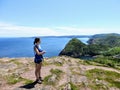 A young female hiker standing above the atlantic ocean overlooking Quidi Vidi and the rugged coast of Newfoundland and Labrador Royalty Free Stock Photo