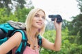 Young female hiker using binoculars in forest Royalty Free Stock Photo