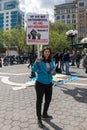 Young female hold up a sign at the May Day International Workers Day Event in Union Square