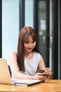 Female holding credit card and using smart phone for making shopping online. Royalty Free Stock Photo