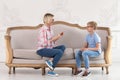 Young female home tutor and her happy pupil sitting on sofa and doing exercise with cards. Education at home Royalty Free Stock Photo