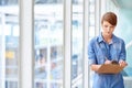 Young female intern taking notes on clipboard next to windows Royalty Free Stock Photo