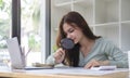 Young female investor examining financial documents with magnifying glass Royalty Free Stock Photo