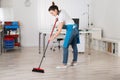 Female Janitor Sweeping Floor With Broom Royalty Free Stock Photo