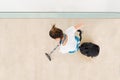 Young Female Janitor Vacuuming Floor Royalty Free Stock Photo