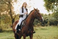 A young female jockey is sitting on her horse in show jumping training. Preparing for the competition. Royalty Free Stock Photo