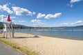 A young female lifeguard stands on duty at a lifeguard station along the sandy city beach at Sandpoint, Idaho