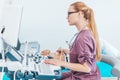 Young female blonde doctor with black glasses. Ultrasound scanner in the hands of a doctor. Diagnostics. Sonography Royalty Free Stock Photo