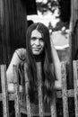 Young female with long hair, portrait, standing near the wooden fence in the village. Royalty Free Stock Photo