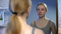 Young female looking at puberty face acne in mirror reflection feeling depressed Royalty Free Stock Photo