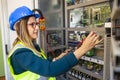 Young female maintenance engineer testing voltage with digital multimeter