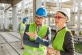 Young male and female architects or business partners talking and discussing  on a construction site Royalty Free Stock Photo