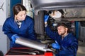 Female master with foreman are repairing car