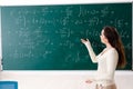 The young female math teacher in front of chalkboard Royalty Free Stock Photo