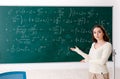 The young female math teacher in front of chalkboard Royalty Free Stock Photo