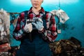 Young female mechanic in uniform and gloves, holding a tool. Close-up of the employee`s hands Royalty Free Stock Photo