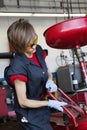 Young female mechanic working on welding equipment