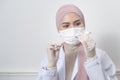 Young female muslim doctor holding a syringe with covid-19 vaccine bottle for injection, covid-19 vaccination and health care Royalty Free Stock Photo