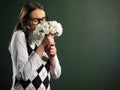 Young female nerd smelling bouquet of flowers Royalty Free Stock Photo