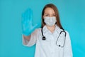 Young female NHS doctor hand gesturing STOP Coronavirus COVID-19 2019-ncov disease global pandemic outbreak,please help
